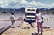 1974_MEXICO, Yucatan, offenbar hatten wir die Regenzeit erwischt_in vielen Gegenden bis und in Yucatan gab�s �berschwemmungen _ teilweise war das Vorw�rtskommen nur auf D�mmen und / oder per kleiner Seilf�hren m�glich, welche die Bauern oder das Milit�r errichtet hatten_ manch- mal hiess es aber nur einfach abwarten, bis das Wasser ab- geflossen war und die Pisten durch die Sonne wieder hart wurden_denn wehedem, man fuhr durch den Schlamm wei- ter_in den Bergen rutschte man seitlich Richtung Abgrund_ oder der Wagen blieb im Schlamm stecken_ dieser wurde dann sp�ter in der Sonne  hart wie Zement_ hier: OPHELIA beim Fahrzeug-Dirigieren
