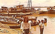 per Flieger ging�s weiter bis IQUITOS (am Amazonas) in Peru und weiter per Flieger bis Leticia (am Amazonas) in Kolumbien_Angelika macht Zigaretten-P�uschen am Anlegeplatz der Amazonas-Boote_1975_Jochen A. H�bener